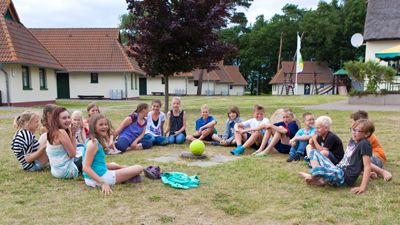 Spielende Kinder zwischen den Bungalows des Jugendtours-Feriendorfes Ummanz / Insel Rügen